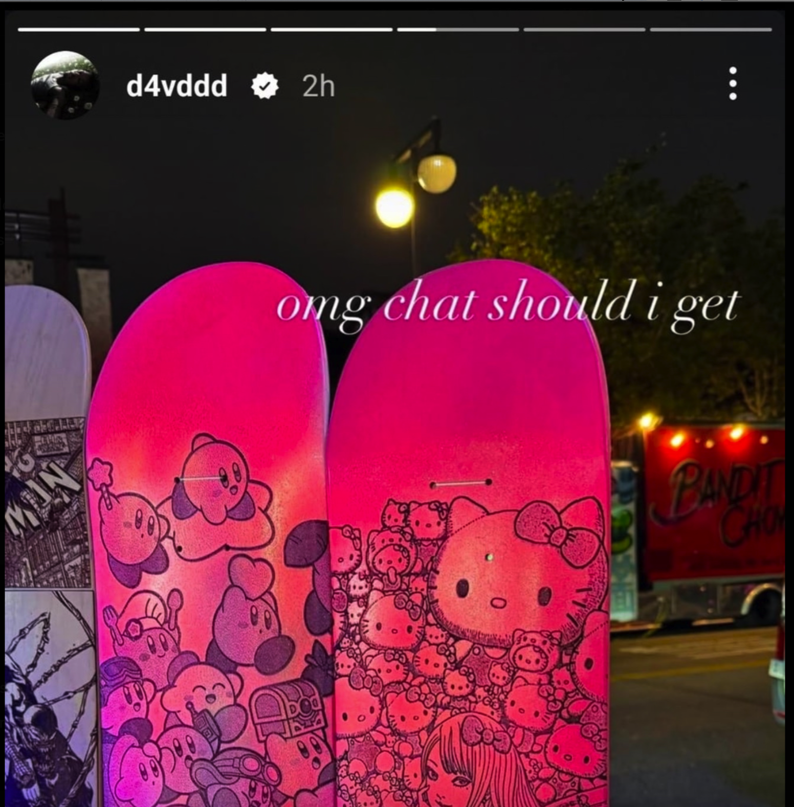 d4vd Instagram Story from May 5, 2025: two skateboards with Kirby and Hello Kitty artwork at a night market, captioned 'omg chat should i get'